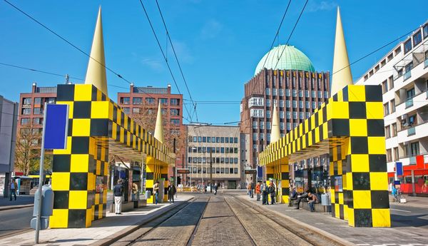 Eine Haltestelle in Hannover. Die sehr großen Wartehäuschen sehen aus, als wären sie aus schwarzen und gelben Legosteinen zusammengesetzt.