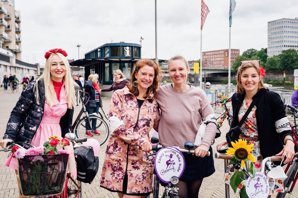 Vier Frauen in bunter Kleidung und mit Fahrrädern nehmen am Fancy Women Bike Ride in Bremen teil. Die zweite von rechts ist die Vorsitzende des VCD Bremen, Katharina Bermpohl.