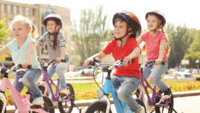 Vier Kinder fahren auf ihren Fahrrädern durch eine Stadt