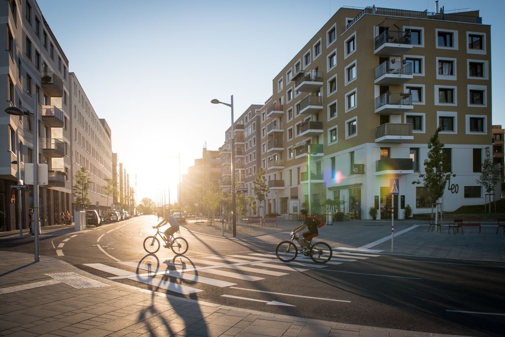 Sonnenuntergang in der Seestadt Aspern, im Vordergrund sieht man Radfahrer und Fußgänger