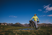 Auf dem Bild ist ein Mountainbiker in den Bergen zu sehen.