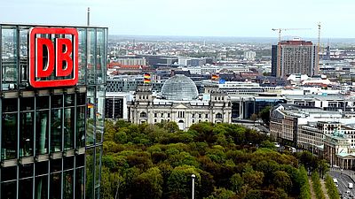Das Luftbild zeigt im Vordergrund den Bahntower in Berlin und im Hintergrund den Reichstag