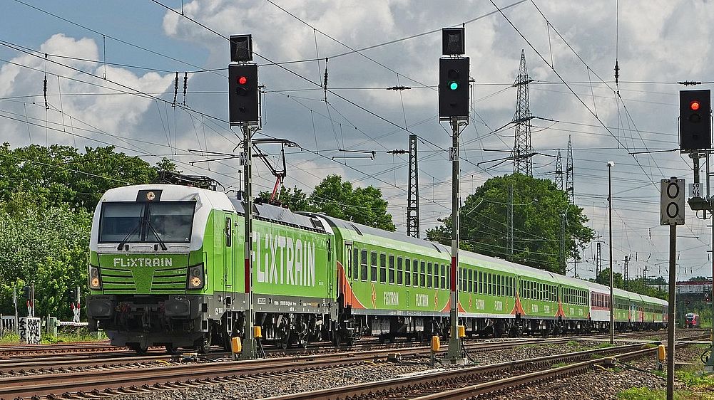 Flixtrain Ein Zug des Unternehmens Flixtrain fährt durch eine Landschaft