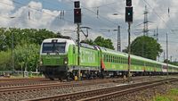 Ein Zug des Unternehmens Flixtrain fährt durch eine Landschaft