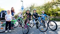 Kinder posieren mit ihren Fahrrädern und lachen
