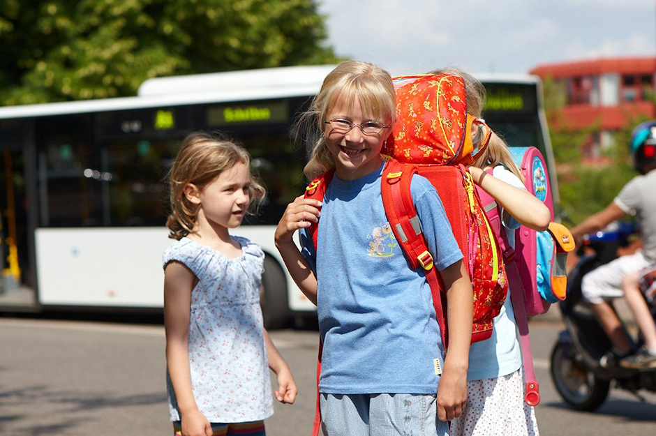 Schulkinder neben Bus