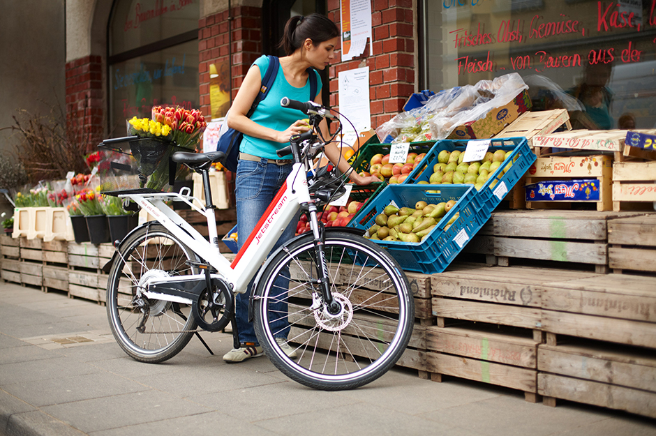 Frau mit Fahrrad bei Einkauf